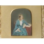 A small Victorian portrait of a young lady seated at a table - probably watercolours on a printed