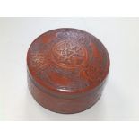 A 20thC Eastern circular lidded box having tooled leather decoration, 5" diameter.