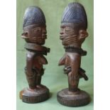 A pair of African Yoruba Ibeji figures, each with metal jewellery, 9.75" high.