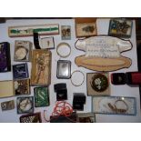 A tin of costume jewellery and other items.