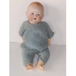 An Armand Marseille bisque head baby doll with blue paperweight sleeping eyes, jointed composition