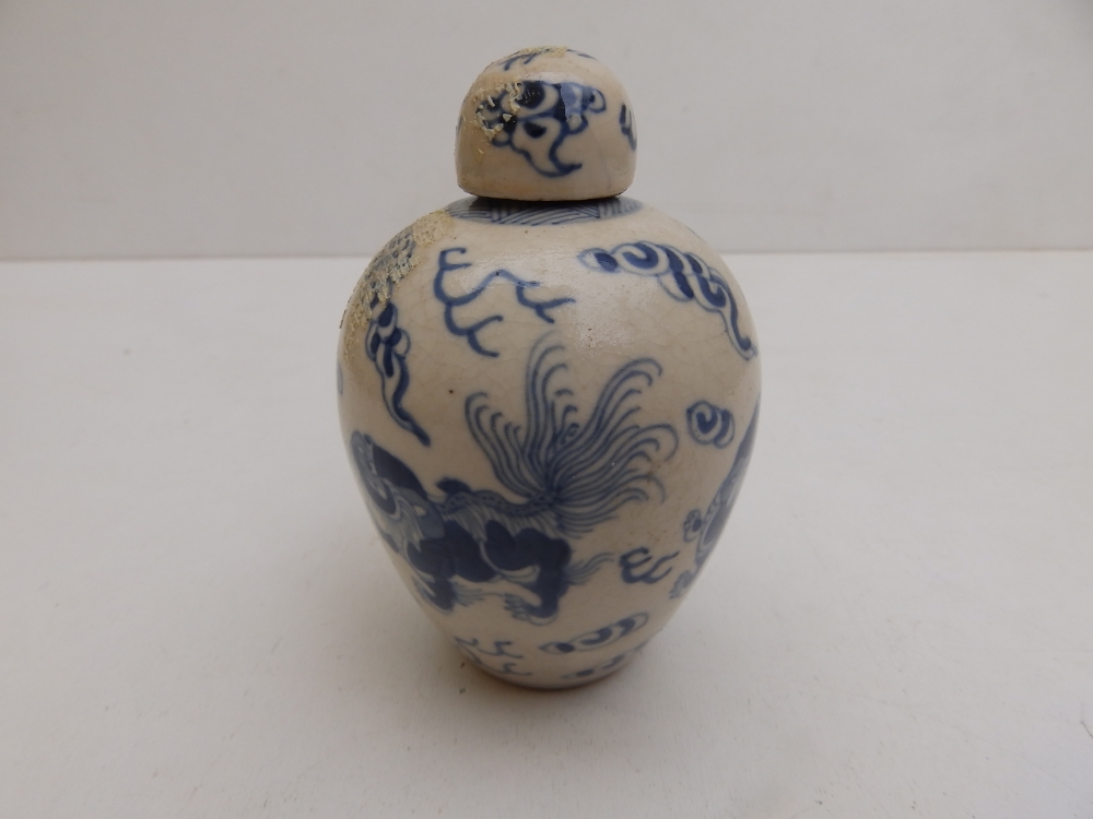 A small Chinese covered blue & white porcelain jar decorated with cavorting shishis amidst cloud - Image 2 of 7