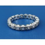 An illusion set diamond eternity ring in white metal. Finger size J.