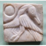 A small carved marble panel depicting two birds with the Sun, 3.5".
