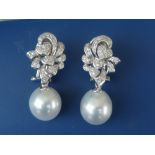 A pair of diamond & cultured pearl set 18ct white gold drop earrings, each comprising a diamond