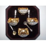 A cased set of four Edwardian square silver trencher salts with gilt interiors and matching