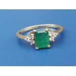 An emerald & diamond set 18ct gold ring, the rectangular emerald flanked by six small diamonds.