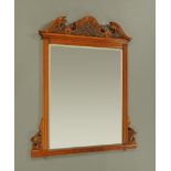 A late Victorian carved oak overmantle mirror, with bevelled glass and shaped pediment.