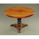 A 19th century German breakfast table, mahogany with circular top, turned column and triform base.