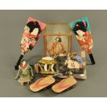 Three Japanese face decorated bats, a cased water carrier figure and a pair of lacquered shoes.