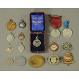 A collection of medallions, fobs and coins, including a Victoria Jubilee brooch.