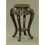 A Chinese carved wooden jardiniere stand, with circular top and raised on cabriole legs.