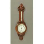 A carved oak cased aneroid barometer with mercury thermometer. Height 87 cm.