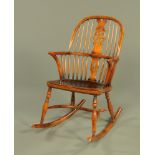 A Titchmarsh & Goodwin Windsor style rocking chair, with dished elm seat and central wheel splat.