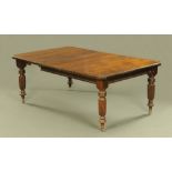A late Victorian mahogany dining table, with one leaf with canted angles and raised on turned legs.