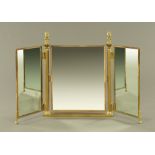 A brass framed dressing table mirror, with lion terminals.