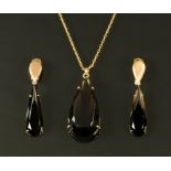 A smoky quartz pendant in gold coloured metal mount, together with a pair of matching ear clips,
