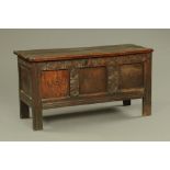 An 18th century oak coffer, with three plank top and three panelled front,