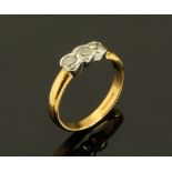 An 18 ct gold two tone three stone diamond set rubover ring, diamonds weighing +/- .50 carats.