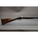 A 12 bore side by side shotgun, with 28" sleeved barrels, cylinder and improved choke,