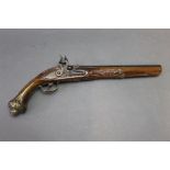 A decorative flintlock pistol, with carved stock and brass furniture. Overall length 43 cm.