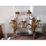 A pair of gilt metal three branch wall light fittings