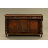 An oak sideboard, formerly a court cupboard top, now raised on short feet.