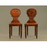 A pair of Regency mahogany oval back hall chairs.