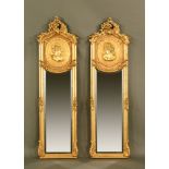 A pair of classical style gilt framed mirrors, with scrolling pediments above a cameo and mirror.