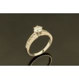 An 18 ct white gold brilliant cut diamond ring, the centre diamond .