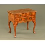 An early 18th century Georgian burr walnut veneered lowboy.