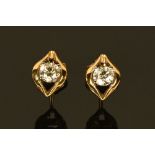 A pair of 18 ct two tone gold stud earrings, set with diamonds weighing +/- .64 carats.