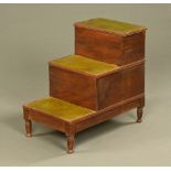 A George III mahogany step commode, with tooled leather treads and raised on turned legs.