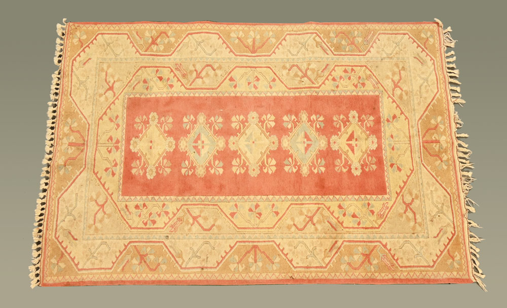 A Persian style woollen fringed rug, with centre rectangular panel and multiple line border,