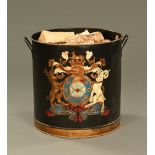 A large painted cylindrical log receiver, with coat of arms and carrying handle to either side.