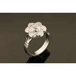 An 18 ct gold diamond daisy cluster ring, the centre diamond +/- .