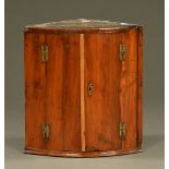 A George III yew wood bow fronted hanging corner cabinet. Height 61 cm, width 56 cm, depth 37 cm.