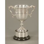 A George V silver trophy, with plain girdled body and leaf capped handles.