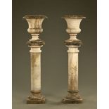 A pair of marble urns on plinths, probably 19th century, the urns Campana shaped,