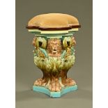 A 19th century Majolica triform seat, with lion masks and paw feet,