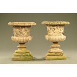 A pair of composition garden urns, Campana shape, each raised on a stepped base.