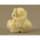 A Chinese carved jade male figure seated on a mythical creature. Length 52 mm.