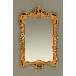 An 18th century style carved giltwood mirror. Height 131 cm, width 80 cm (see illustration).