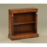 An Empire style mahogany open bookcase, with Egyptian style pilasters and raised on a plinth base.