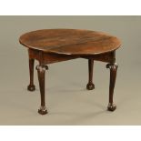 A George II mahogany gate leg table, raised on boldly carved cabriole legs and claw and ball feet.