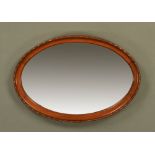 An Edwardian mahogany oval framed mirror, with bevelled glass. 85 cm x 59 cm.