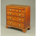 An early 19th century oak and mahogany banded chest of drawers,