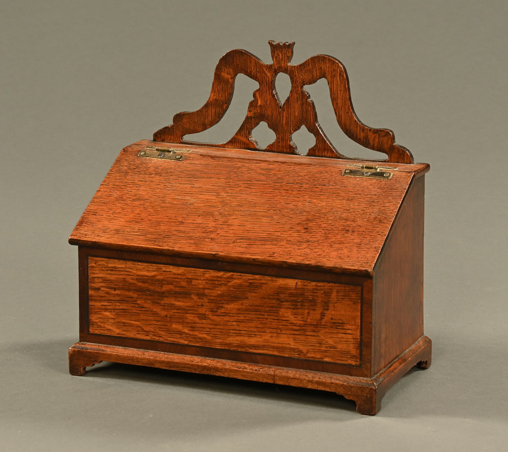 A Georgian oak salt box, with fretwork pediment slope front and raised on bracket feet.