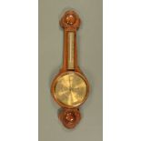 A carved oak aneroid barometer, circa 1930 and with mercury thermometer. Height 79 cm.