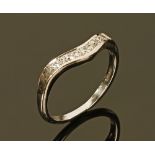 An 18 ct white gold diamond set wave shaped ring. Size M. 2.7 grams.